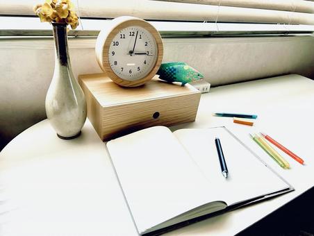 机の上の置時計とノート